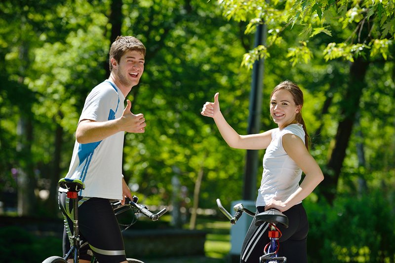 Happy couple riding bicycle outdoors